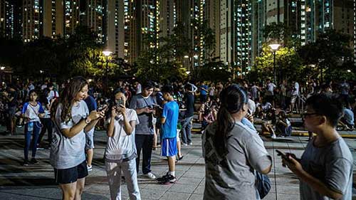 在新界元朗的天水圍，成百上千的人群在晚間聚集公園內玩遊戲。
